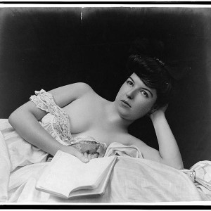 748px-Young_woman,_wearing_negligee,_lying_in_bed,_holding_book