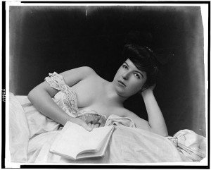 748px-Young_woman,_wearing_negligee,_lying_in_bed,_holding_book