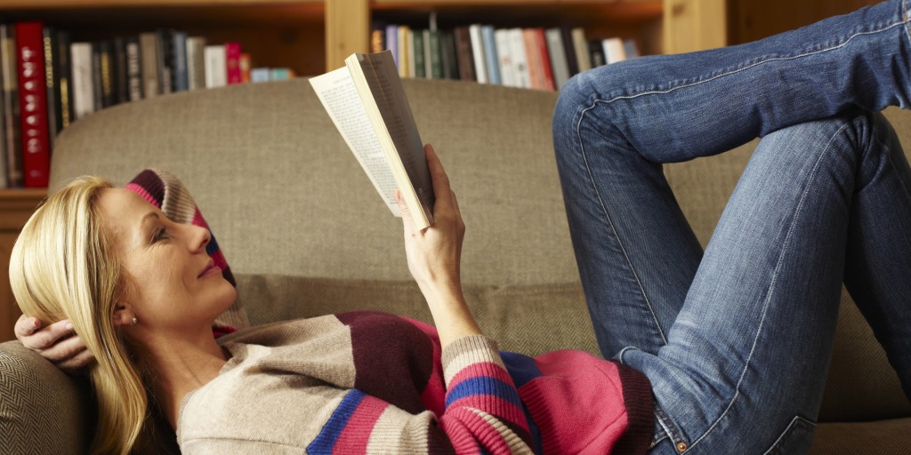 Woman reading book on sofa