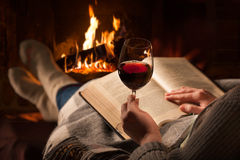 woman-reads-book-near-fireplace-resting-glass-red-wine-68573271