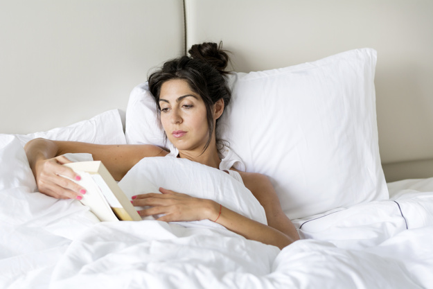 woman-reading-a-book-in-bed_1169-80