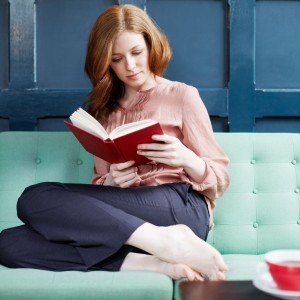woman-reading-a-book-on-sofa--117845380-5977a22c519de200119d6f32