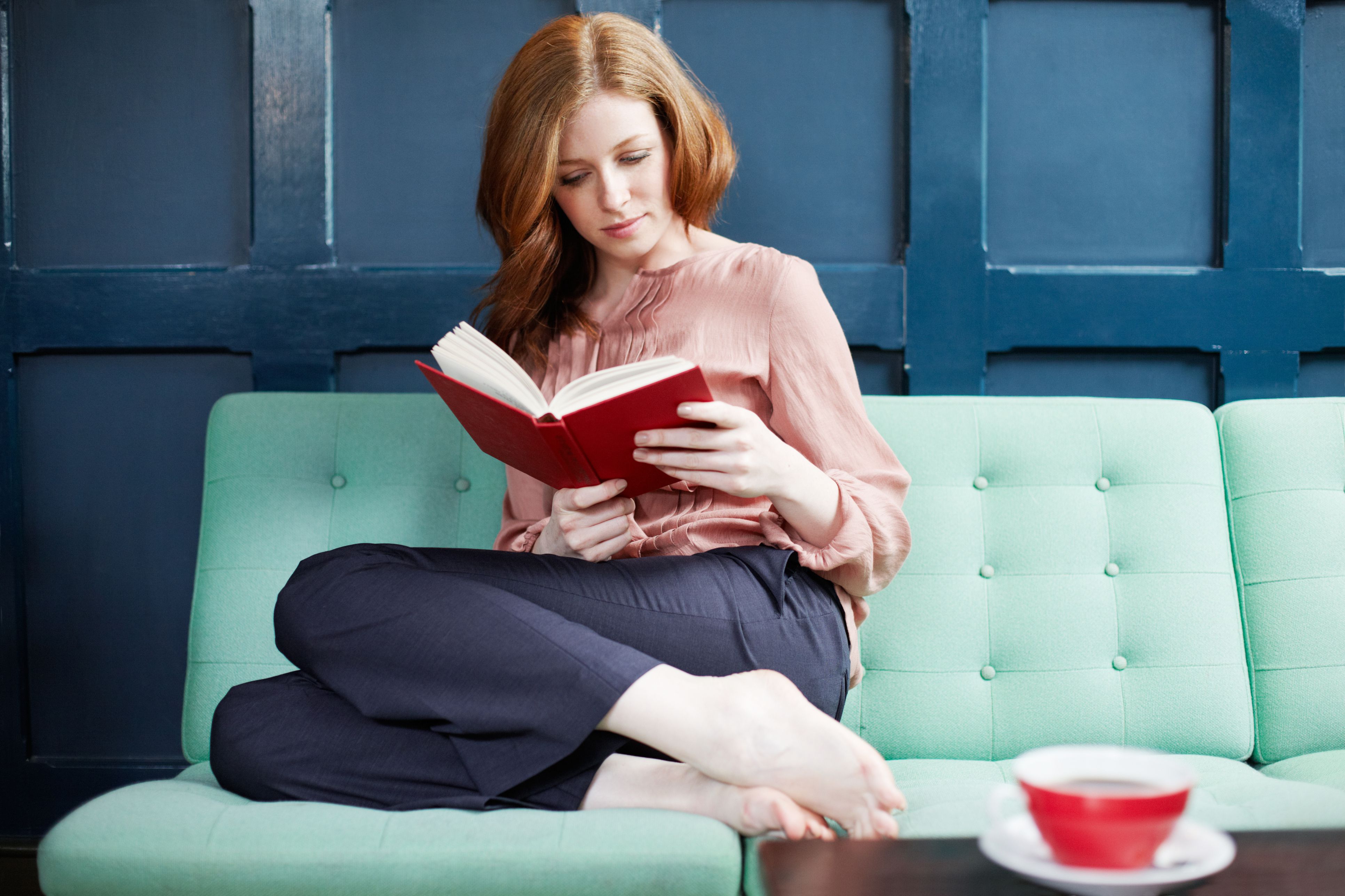 woman-reading-a-book-on-sofa--117845380-5977a22c519de200119d6f32