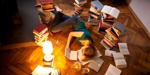 Young woman lying and sleeping on floor, surrounded by books --- Image by © Matthias Tunger/Corbis