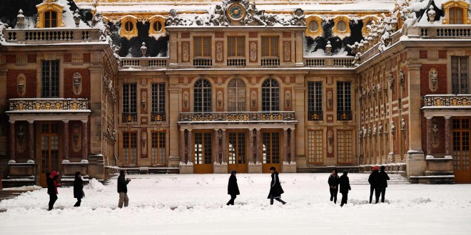 People walk past the snow-covered Palace of Versailles on February 7, 2018 in Versailles, outside of Paris. 
Exceptionally heavy snowfall brought public transport in Paris and surrounding regions to a near halt on February 7, spelling misery for commuters after hundreds were forced to abandon their cars to sleep in emergency shelters overnight. / AFP PHOTO / CHRISTOPHE SIMONCHRISTOPHE SIMON/AFP/Getty Images