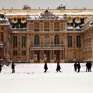 People walk past the snow-covered Palace of Versailles on February 7, 2018 in Versailles, outside of Paris. 
Exceptionally heavy snowfall brought public transport in Paris and surrounding regions to a near halt on February 7, spelling misery for commuters after hundreds were forced to abandon their cars to sleep in emergency shelters overnight. / AFP PHOTO / CHRISTOPHE SIMONCHRISTOPHE SIMON/AFP/Getty Images