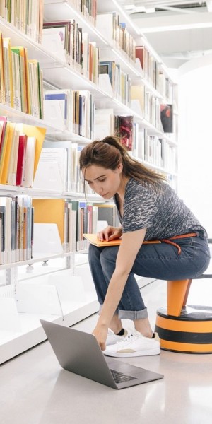 woman-working-on-a-laptop-in-a-library-galleries-libraries-and-museums